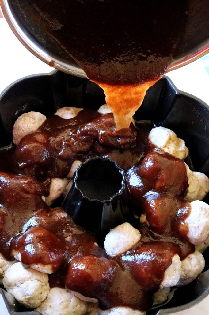 Amish Friendship Bread Monkey Bread cinnamon mixture poured over dough balls in Bundt pan | friendshipbreadkitchen.com