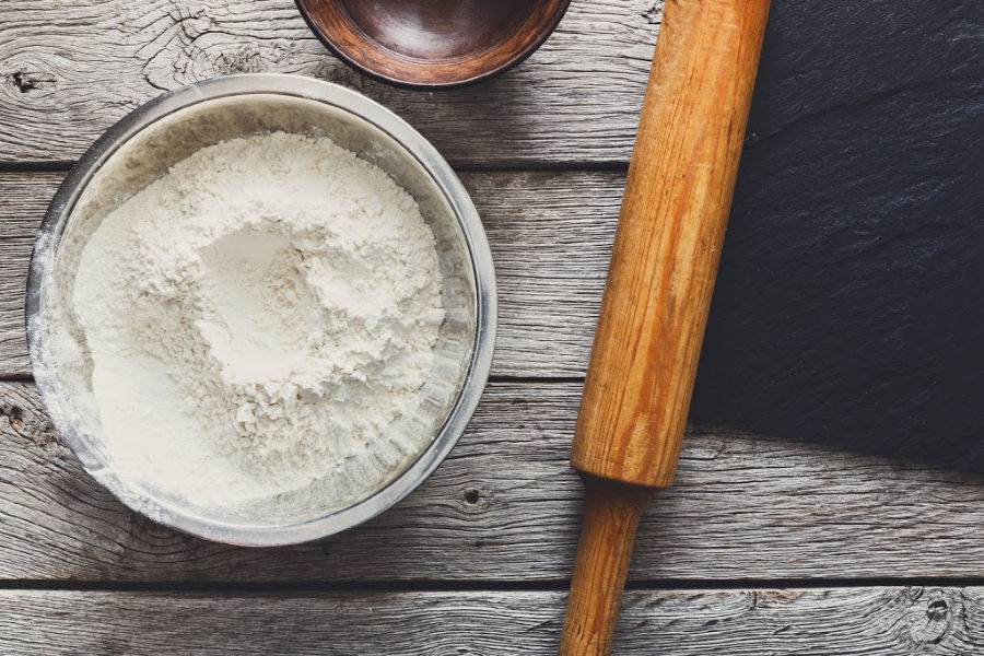 A bowl of Amish Friendship Bread flour next to a rolling pin