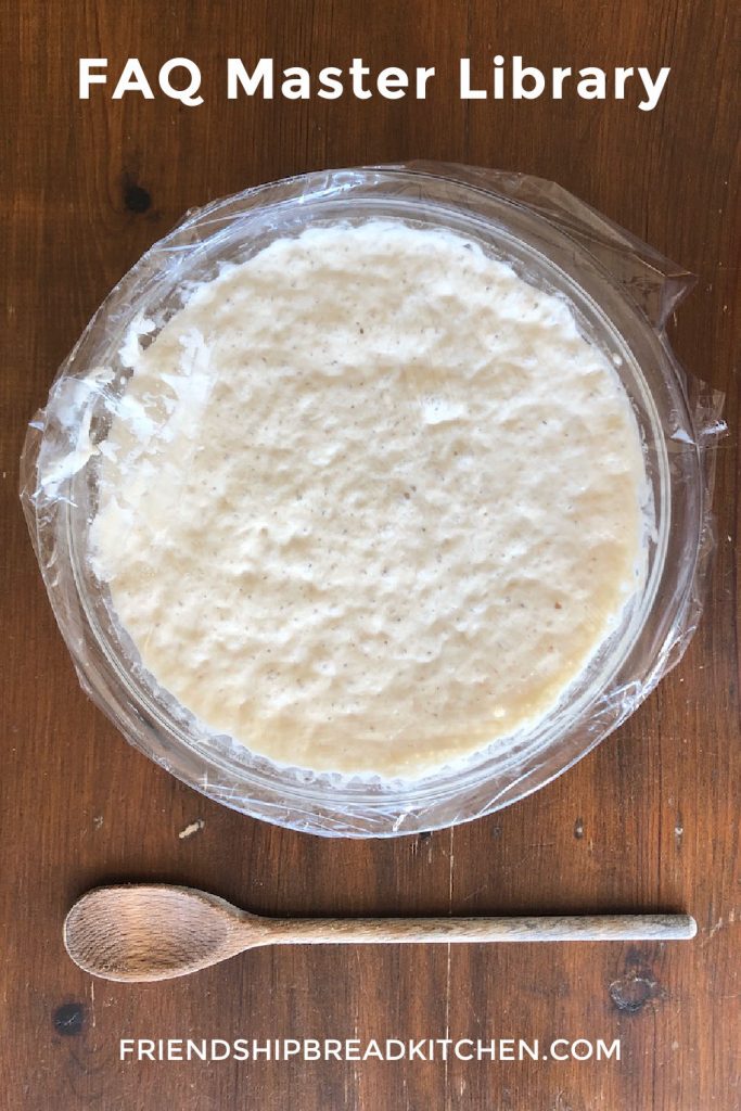 Bowl of Amish Friendship Bread starter on a wooden table next to a wooden spoon.