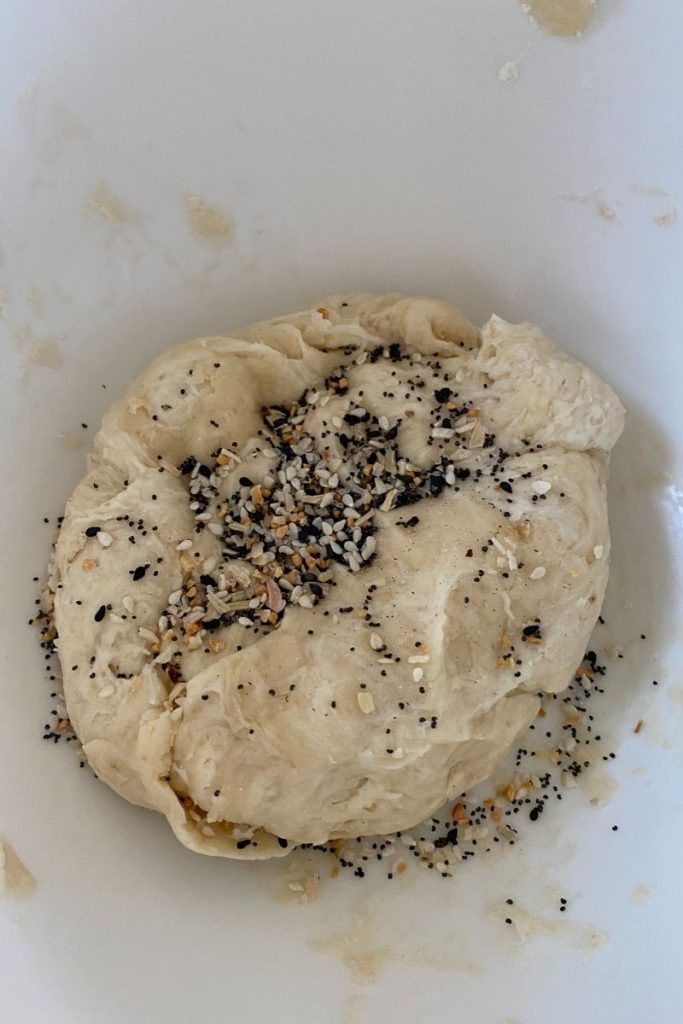 Everything bagel seasoning sprinkled on a ball of dough.