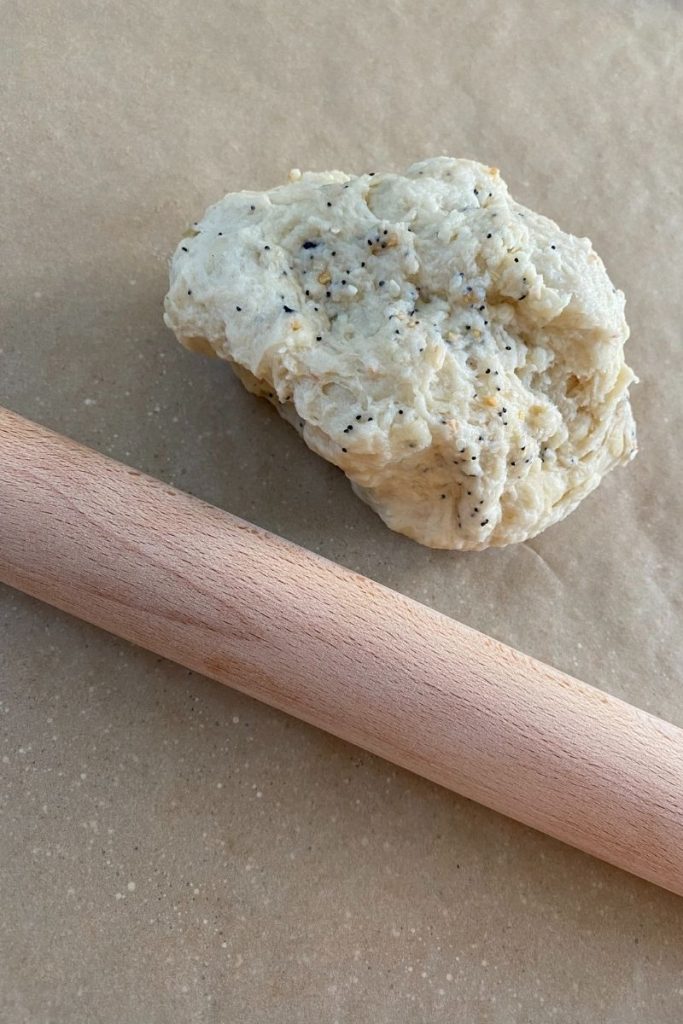 Wood rolling pin over dough on parchment.