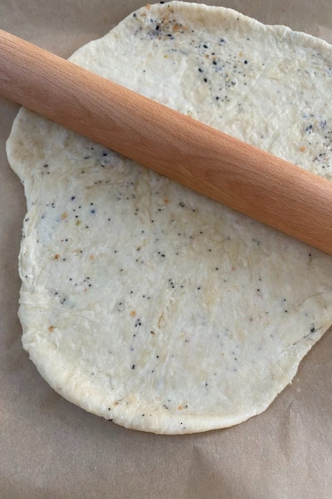 Wood rolling pin over dough on parchment.