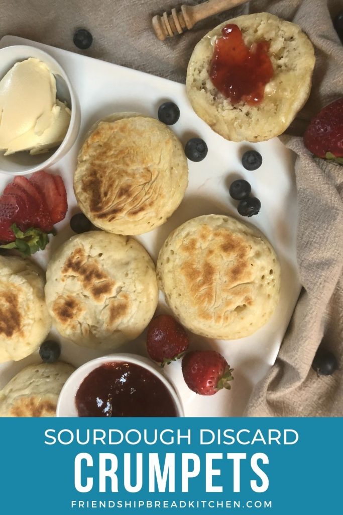 Sourdough crumpets on a board with jam and butter