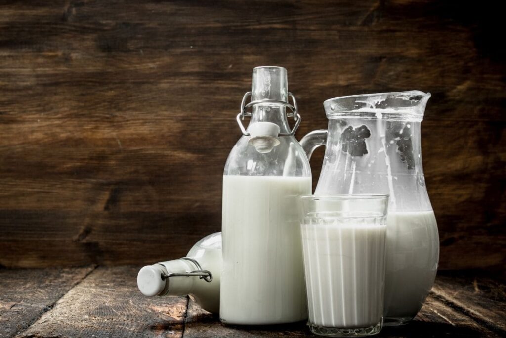 milk substitutes in different cups on a wood table